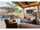 Covered patio with an outdoor kitchen, lounge seating, ceiling fan, and TV for outdoor entertainment at 4422 E Spur Dr, Cave Creek, AZ 85331