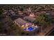 Beautiful home featuring a backyard swimming pool with illuminated water, landscaping, and a privacy wall at 4605 E Swilling Rd, Phoenix, AZ 85050