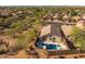 Aerial view showcases a home with a pool, hot tub, private yard, and neighboring houses surrounded by desert vegetation at 4605 E Swilling Rd, Phoenix, AZ 85050