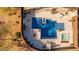Overhead view of a backyard with a mosaic pool, spa, lounge area and patio surrounded by desert landscape and wooden fencing at 4605 E Swilling Rd, Phoenix, AZ 85050