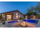 Serene backyard featuring a shimmering pool with integrated fire features and relaxing lounge areas at 4605 E Swilling Rd, Phoenix, AZ 85050