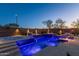 Amazing outdoor pool with vibrant blue lighting, fire features, and privacy fencing at 4605 E Swilling Rd, Phoenix, AZ 85050
