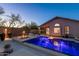 Inviting backyard pool with blue lighting, a fire pit, outdoor seating, and an outdoor kitchen at 4605 E Swilling Rd, Phoenix, AZ 85050