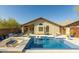Exterior view of the home showcases a refreshing mosaic tiled pool and an elegant patio setup for outdoor lounging and relaxation at 4605 E Swilling Rd, Phoenix, AZ 85050