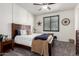 Comfortable bedroom featuring a bed with a wooden headboard, modern farmhouse decor, and neutral carpet at 5212 S Seton Ct, Gilbert, AZ 85298