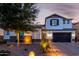 Elegant two-story home featuring a dark garage door, stucco siding, stone accents, and professional desert landscaping at 5212 S Seton Ct, Gilbert, AZ 85298