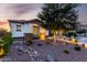 Beautiful desert landscaped front yard with rocks, accent lighting, and a mature shade tree at 5212 S Seton Ct, Gilbert, AZ 85298