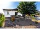 Beautiful desert landscaped front yard with rocks, accent lighting, and a mature shade tree at 5212 S Seton Ct, Gilbert, AZ 85298
