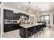 Chef's kitchen with island, stainless appliances, black cabinets, and open to dining area at 5212 S Seton Ct, Gilbert, AZ 85298