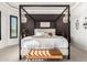 This main bedroom features a four poster bed, elegant chandeliers and rich accent wall at 5212 S Seton Ct, Gilbert, AZ 85298