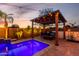 Backyard pool with lighting, outdoor kitchen, pergola, and outdoor seating for entertaining at 5212 S Seton Ct, Gilbert, AZ 85298