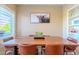 Dining room with wood table, leather chairs, stylish decor, and natural light from a large window at 5345 E Van Buren St # 307, Phoenix, AZ 85008
