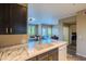 Bright kitchen with white marble countertops, dark cabinetry, and stainless steel appliances at 5345 E Van Buren St # 307, Phoenix, AZ 85008