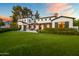 Expansive backyard featuring lush green lawn, patio with pergola, and elegant landscaping, perfect for outdoor entertaining at 5929 E Indian School Rd, Phoenix, AZ 85018