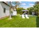 Lush backyard with artificial grass, in-ground pool, lounge chairs and a covered patio at 5929 E Indian School Rd, Phoenix, AZ 85018