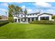 Expansive backyard with lush lawn, and a charming two-story home, perfect for outdoor entertaining at 5929 E Indian School Rd, Phoenix, AZ 85018