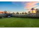 Expansive backyard view with a gazebo, lush lawn, and the golf course beyond the hedge at 5929 E Indian School Rd, Phoenix, AZ 85018
