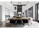 Open-concept dining area features a large wooden table, modern chairs, and an elegant lighting fixture at 5929 E Indian School Rd, Phoenix, AZ 85018