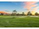 Scenic view of the golf course with lush green fairways and trees under a colorful sky at 5929 E Indian School Rd, Phoenix, AZ 85018