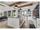 Open kitchen features a large island, modern pendant lights, stainless steel appliances, and rustic beams at 5929 E Indian School Rd, Phoenix, AZ 85018