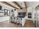 Modern kitchen with stainless steel appliances, a large island, pendant lighting, and rustic beam accents at 5929 E Indian School Rd, Phoenix, AZ 85018