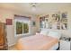Cozy bedroom with a white comforter, natural light, and an array of Gathering photos at 6102 E Inglewood St, Mesa, AZ 85205