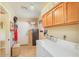 Functional laundry area with washer, dryer, and overhead cabinets, accompanied by a secure safe for valuables at 6102 E Inglewood St, Mesa, AZ 85205