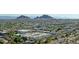 An aerial perspective of a vibrant neighborhood featuring modern architecture, verdant landscaping, and distant mountain peaks at 7021 E Earll Dr # 204, Scottsdale, AZ 85251