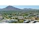An aerial view of modern homes and condos nestled amidst lush greenery with mountains in the backdrop on a clear, sunny day at 7021 E Earll Dr # 204, Scottsdale, AZ 85251
