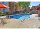 Community swimming pool area with an umbrella-covered table and lounge chairs at 7021 E Earll Dr # 204, Scottsdale, AZ 85251