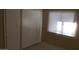 Bright bedroom featuring neutral walls, tile floor, built-in storage and a window allowing ample natural light at 7109 W Wolf St, Phoenix, AZ 85033