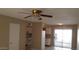 Inviting living space with adjacent kitchen, access to outdoor patio, neutral colors, and ceiling fan at 7109 W Wolf St, Phoenix, AZ 85033