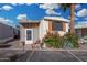 Charming home featuring an enclosed porch, shuttered window, and vibrant floral landscaping at 730 S Country Club Dr # Ofc, Mesa, AZ 85210