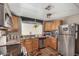 Updated kitchen with stainless steel appliances, wood cabinets, and view into the dining area at 730 S Country Club Dr # Ofc, Mesa, AZ 85210