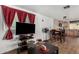 Open-concept living room with kitchen featuring dining table, television, and red curtains at 730 S Country Club Dr # Ofc, Mesa, AZ 85210