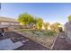 A backyard space featuring a gravel border, minimal grass, and partial stone steps at 7319 S 56Th Dr, Laveen, AZ 85339