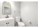 Powder room with a modern vanity, toilet, and decorative mirror at 7319 S 56Th Dr, Laveen, AZ 85339