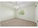 A bright bedroom featuring carpeted floors, a ceiling fan, and a sunlit window at 7319 S 56Th Dr, Laveen, AZ 85339