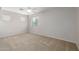 A spacious bedroom featuring carpeted floors, a ceiling fan, and sunlit windows at 7319 S 56Th Dr, Laveen, AZ 85339