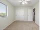 A bedroom featuring carpeted floors, a ceiling fan, closet, and a sunlit window at 7319 S 56Th Dr, Laveen, AZ 85339
