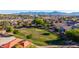 Aerial view of residential neighborhood, with a community park surrounded by houses and distant mountains at 7319 S 56Th Dr, Laveen, AZ 85339