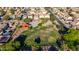 Aerial view of community park with playground, basketball court, and green spaces in a residential area at 7319 S 56Th Dr, Laveen, AZ 85339