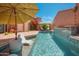 Beautiful pool area features a waterfall, two lounge chairs, and two patio umbrellas at 7530 N Via De La Siesta --, Scottsdale, AZ 85258