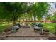 Outdoor patio area featuring a brick firepit and comfortable seating under mature trees at 8302 S Jentilly Ln, Tempe, AZ 85284