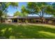 Covered patio area, a long backyard, lush landscaping, and a well-maintained lawn at 8302 S Jentilly Ln, Tempe, AZ 85284
