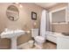 Well-lit bathroom with a pedestal sink, white fixtures, and a tiled tub-shower combo at 8302 S Jentilly Ln, Tempe, AZ 85284