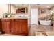 Bathroom featuring dual sinks, granite countertops, and stand alone tub at 8302 S Jentilly Ln, Tempe, AZ 85284