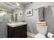 Upstairs bathroom with a dark cabinet vanity, square mirror, and gray accent walls at 8302 S Jentilly Ln, Tempe, AZ 85284