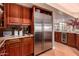 Kitchen featuring stainless steel refrigerator, wooden cabinets, granite countertop, and hardwood floors at 8302 S Jentilly Ln, Tempe, AZ 85284