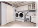 Basement laundry room with white cabinets, utility sink, and front loading washer and dryer at 8302 S Jentilly Ln, Tempe, AZ 85284